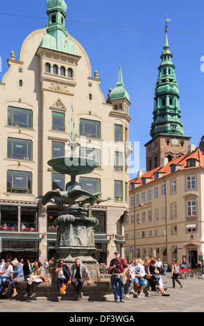 Menschen durch den Storch Brunnen auf Amagertorv Platz mit alten Gebäuden und St. Nikolaj-Kirche Turm Amager Torv, Kopenhagen Dänemark Stockfoto