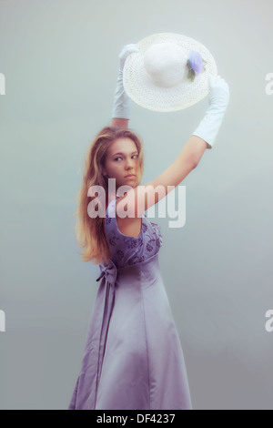 eine schöne Frau mit langen blonden Haaren trug Handschuhe und einen Sonnenhut Stockfoto