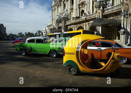 Cocotaxi und Oldtimer Autos geparkt vor der großen Theater von Havanna - Havanna, Kuba Stockfoto