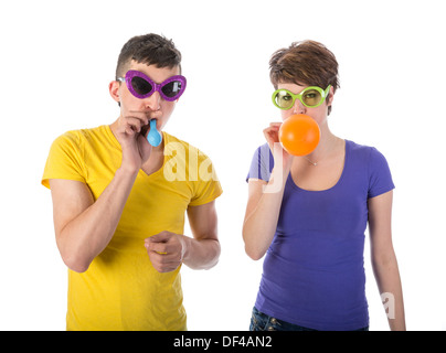 Mann und Frau mit Sonnenbrille bläst Luftballons Stockfoto