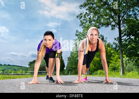 Urbane Sportarten - junge Frauen tun warming up vor der Ausführung in der grünen Wiese an einem Sommertag Stockfoto