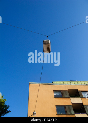 Straßenlaterne und Kabel, Gebäude gegen blauen Himmel, Low Angle View Stockfoto