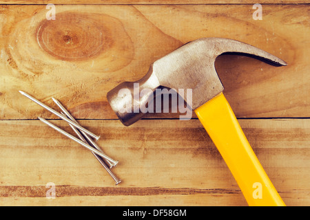 Hammer und Nägel auf Holz Stockfoto