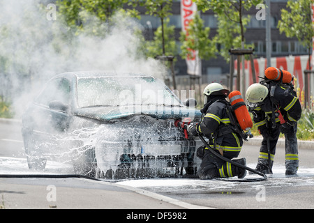Feuerwehrleute sind nur ein brennen und Rauchen Auto auf die Straße setzen Stockfoto