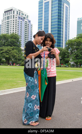 Frauen schauen Sie sich Fotos in Mahabandoola Garden Park in Yangon, Birma. Stockfoto