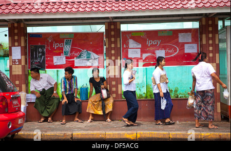 Leute warten an einer Bushaltestelle in Yangon, Birma. Stockfoto