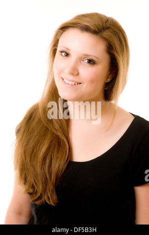 Eine junge kaukasische Frau mit langen, hellbraunen Haaren fegte über ihre Schulter und schaute lächelnd auf die Kamera. Stockfoto