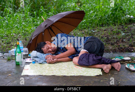 Ein Mann schläft auf dem Bahnhof in Yangon, Birma. Stockfoto