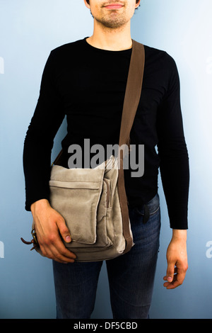 Junger Mann mit einer Messenger-Tasche über die Schulter Stockfoto