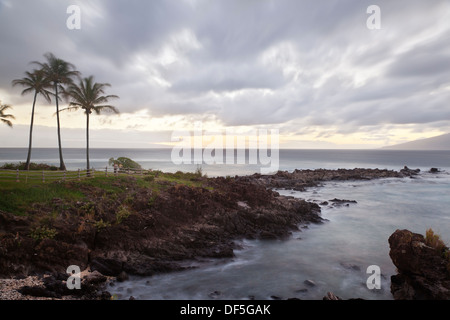 Langzeitbelichtung an Napili Punkt mit Kokosnuss-Palmen bei Sonnenuntergang in Maui, Hawaii. Stockfoto