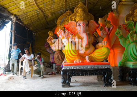 Arbeiter in Indien für den Geburtstag von Lord Ganesha fertigen Idole in behelfsmäßigen Fabriken am Straßenrand sitzen. Stockfoto