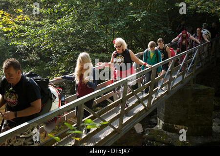 Ngleton UK. 28. September, 2103. Mitglieder von Batala Samba Band Kreuzung Holzsteg en-Route zu Ingleton fällt für ihre Wasserfall Drumming Ereignis. Wasser Musik nahm auf eine andere Bedeutung für die Mitglieder der Samba drumming Band 'Batala Lancaster" am Samstag. Sie spielten ihre Instrumente während in den Stream unter Thornton Kraft stehend - auf ingleton's Wasserfall entfernt. Die Charity Veranstaltung war ein echter Splash für den Longstaffe Educational Foundation, Bentham zu erhöhen. Stockfoto