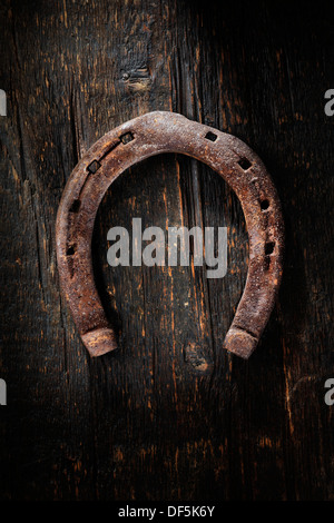 Alten getragen und rostigen Hufeisen auf hölzernen Hintergrund. Stockfoto