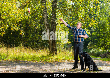 Hundebesitzer schult seine Labrador Retriever auf outdoor, Hund sitzt neben Horizont Format auf Stockfoto