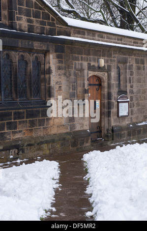 Pfade gelöscht vom Schnee zu Holztür der Kirche Büro & noticeboard an einem verschneiten, Winter's Tag - alle Heiligen Pfarrkirche, Skipton, England, UK. Stockfoto