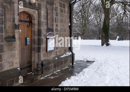 Pfad gelöscht vom Schnee zu Holztür der Kirche Büro & noticeboard an einem verschneiten, Winter's Tag - alle Heiligen Pfarrkirche, Skipton, England, UK. Stockfoto