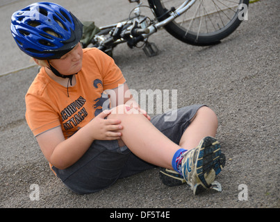 Ein kleiner Junge hat sein Rad abgefallen und verletzte sein Knie (simulierte |). Stockfoto