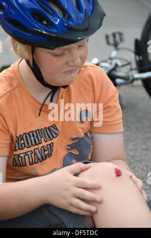 Ein kleiner Junge hat sein Rad abgefallen und verletzte sein Knie (simulierte |). Stockfoto