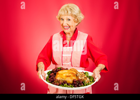 Süße Großmutter hält ein schön warmes Türkei Abendessen. Stockfoto