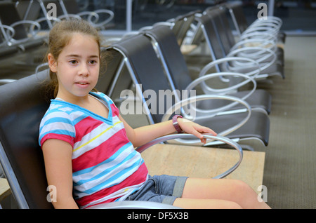 Mädchen am Flughafen - gelangweilter Teenager Mädchen warten auf ihren Flug am Flughafen Stockfoto