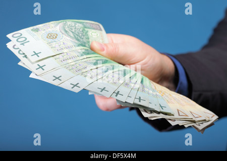 Das Unternehmer Hand mit Polnisch Geld Banknote blau Hintergrund Stockfoto