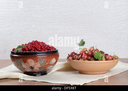 Two ceramic bowl with fresh berries currants and gooseberries Stockfoto