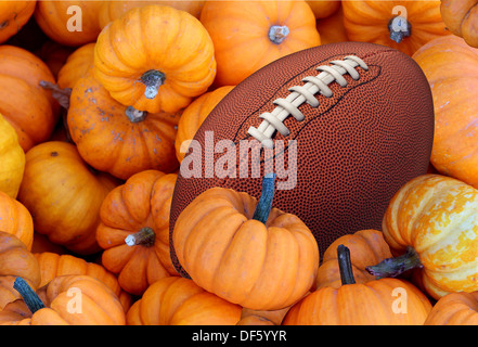 Thanksgiving Day Fußball und Herbst Sport während der Erntezeit mit einem Urlaub Turnier Ball in einem Haufen von orange Kürbisse als Konzept für das Leben eine gesunde Lebensweise-Ernährung und Bewegung oder Fitness. Stockfoto