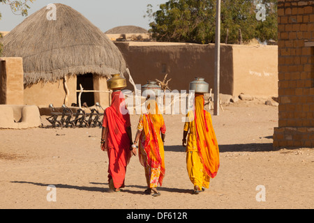 Indien, Rajasthan, Thar-Wüste, drei indische Frauen tragen von Wasser ins Dorf Stockfoto