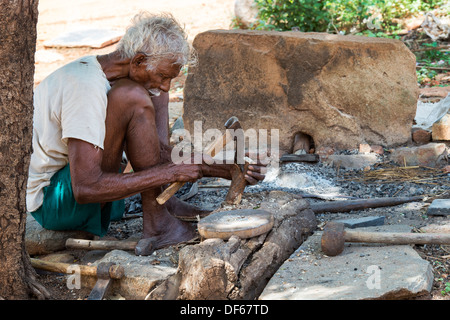 Indische Dorf alte Holz mit einer Axt hacken. Andhra Pradesh, Indien Stockfoto