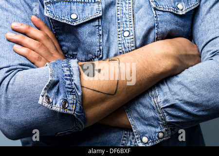 Die Arme des jungen Mannes mit Tattoo Pik-Ass hautnah Stockfoto