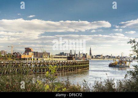 Skyline der Stadt Antwerpen gesehen vom alten Hafen, mit einem Bagger Boot im Vordergrund Stockfoto