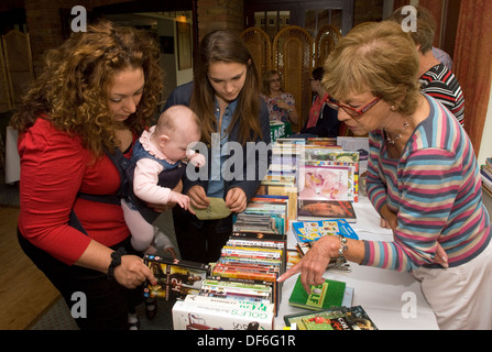 Besucher surfen Buch und DVD bei einer Macmillan Cancer support Kaffee am Morgen, Farnham, Surrey, Großbritannien. Stockfoto