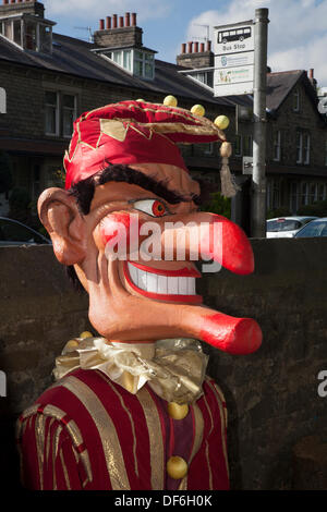 Riesige Marionette Karikatur masquerade Feier in Skipton GROSSBRITANNIEN. 29. September 2013. Internationale Festival der Marionetten. Riesige Angst Punch & Judy Marionetten an der Biennale Internationale Marionette Skipton's Festival mit Theatergruppen aus ganz Europa mit riesigen Puppen mit Händen, Füßen, Spielzeug, Schatten und mit einem Puppenspiel, Punch, Performance, Theater Stage Entertainment, Kinder, traditionelle, Clown, Spaß, Spielen, Judy, Rot, Zeichen, Puppe, lustige, bunte, Veranstaltung, Sommer, Jester, Puppen, Sky, Holz- Riesen animiert. Stockfoto