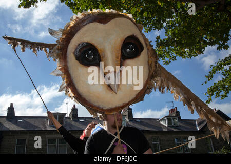 Riesige Tierpuppe Karikatur Maskerade Feier im Skipton UK. September 2013. Internationales Puppentheater. Große Puppentheater  große Rieseneule, veranstaltet von Blake Willoughby 25, & Kate James-Moore, 30 beim Skipton's alle zwei Jahre stattfindenden internationalen Vogelpuppentheaterfestival mit Puppentheatercompanien aus ganz Europa. Die Veranstaltungen boten 44 Vorstellungen mit Tickets sowie 32 kostenlose Straßenvorstellungen. Von riesigen Marionetten bis zu so kleinen Marionetten, dass sie unsichtbar sind, wurde das 5. Skipton International Puppet Festival mit Handpuppen animiert. Stockfoto