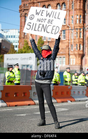 Manchester, UK. 29. September 2013. Eine maskierte Frau ein Schild mit der Aufschrift "Wir werden nicht zum Schweigen gebracht werden" hochhalten, während eine Nord-West TUC organisiert März und Rallye National Health Service (NHS) Arbeitsplätze und Dienstleistungen von Kürzungen und Privatisierungen verteidigen wollte. Der März fällt mit der konservativen Partei Konferenz 2013 in der Stadt statt. Bildnachweis: Russell Hart/Alamy Live-Nachrichten. Stockfoto