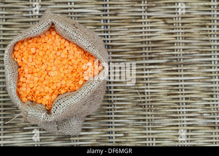 Rote Linsen in Jute-Tasche mit Textfreiraum Stockfoto