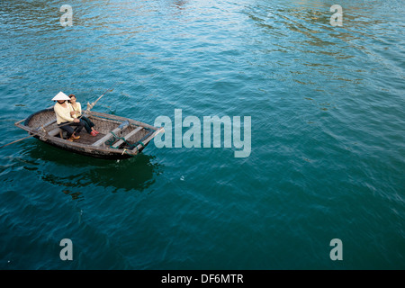 Eine Vietnamesin und ein vietnamesisches Mädchen in einem Ruderboot auf Lan-Ha-Bucht in der Nähe von Cat Ba Town in Halong Bucht, Vietnam. Stockfoto