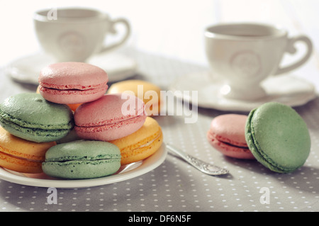 Traditionelles französisches Gebäck - Makronen mit Tasse Tee auf Beige Hintergrund Stockfoto