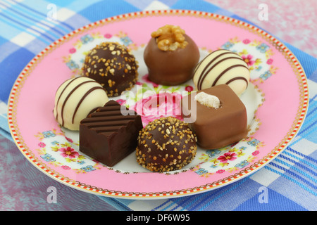Auswahl von Pralinen auf rosa Porzellanteller, Nahaufnahme Stockfoto