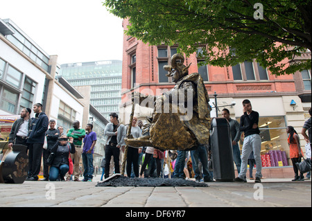 Ein schweben, die Streetart-Künstler an der Market Street im Stadtzentrum von Manchester, führt beobachtet von Passanten. Stockfoto