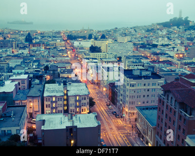 Powell Street in San Francisco, in den frühen Morgenstunden beleuchtet.  Auch Alcatraz (oben links) und Coit Tower (oben rechts). Stockfoto