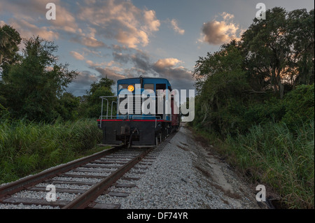 Historischen Zug verlassen das Depot in Tavares, Florida mit Passagieren in der Dämmerung auf einen Cocktail am Abend laufen. Stockfoto