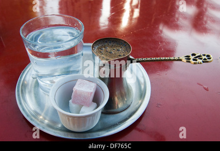 Eine traditionelle Kanne bosnischen Kaffee mit Würfelzucker und ein Glas Wasser serviert. Stockfoto