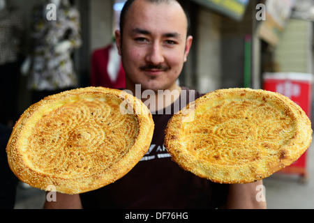 Ein uigurische Bäcker frisch halten gebackenes Naan Brot. Stockfoto