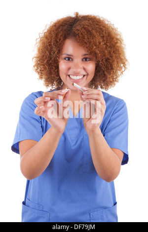 Afrikanische amerikanische Krankenschwester hält eine gebrochene Zigarette, isoliert auf weißem Hintergrund - schwarze Menschen Stockfoto