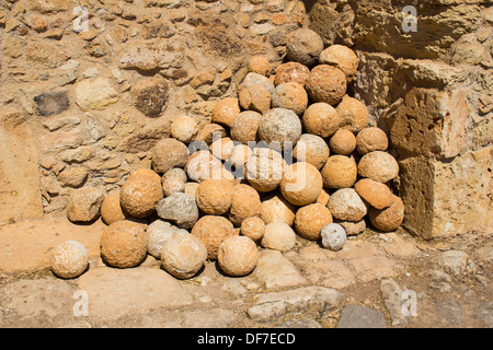 Kanonenkugeln neben eine Wand auf die antike Stadt Aptera in Westkreta gespeichert. Stockfoto