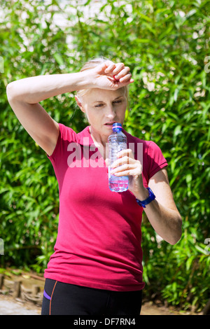 ÄLTERE PERSON MIT KALTEN GETRÄNK Stockfoto
