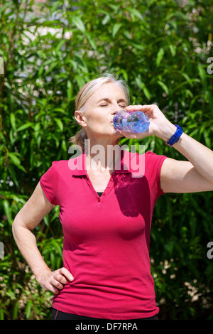 ÄLTERE PERSON MIT KALTEN GETRÄNK Stockfoto