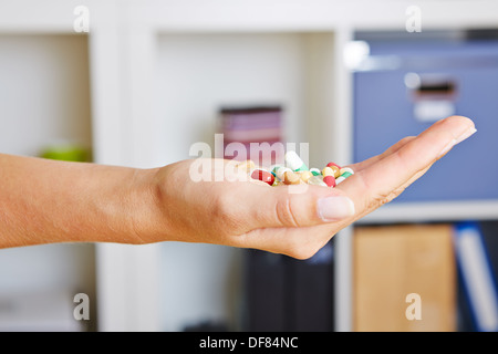 Hand hält viele bunte Pillen in ihre Handfläche Stockfoto