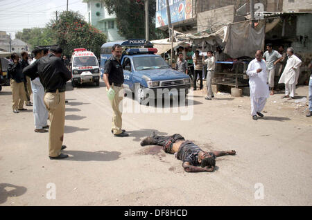 Sicherheitsbeamte zu sammeln, in der Nähe von Leiche von Banditen (Banditen), die sprengte sich mit einer Handgranate während Polizei Begegnung an Soldat Bazar von Karachi auf Montag, 30. September 2013. Stockfoto